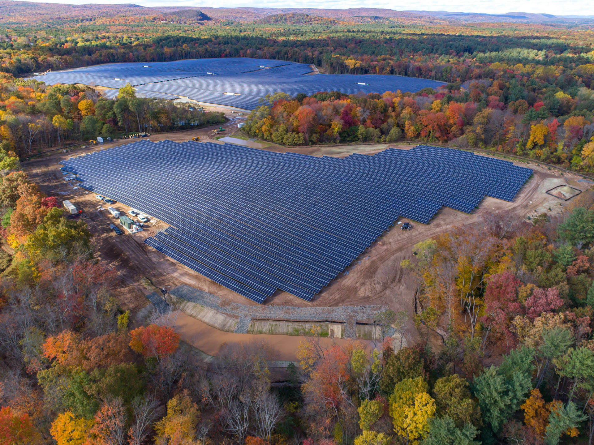 Aerial drone view of Tobacco Valley solar farm surrounded by fall foliage in Connecticut.
